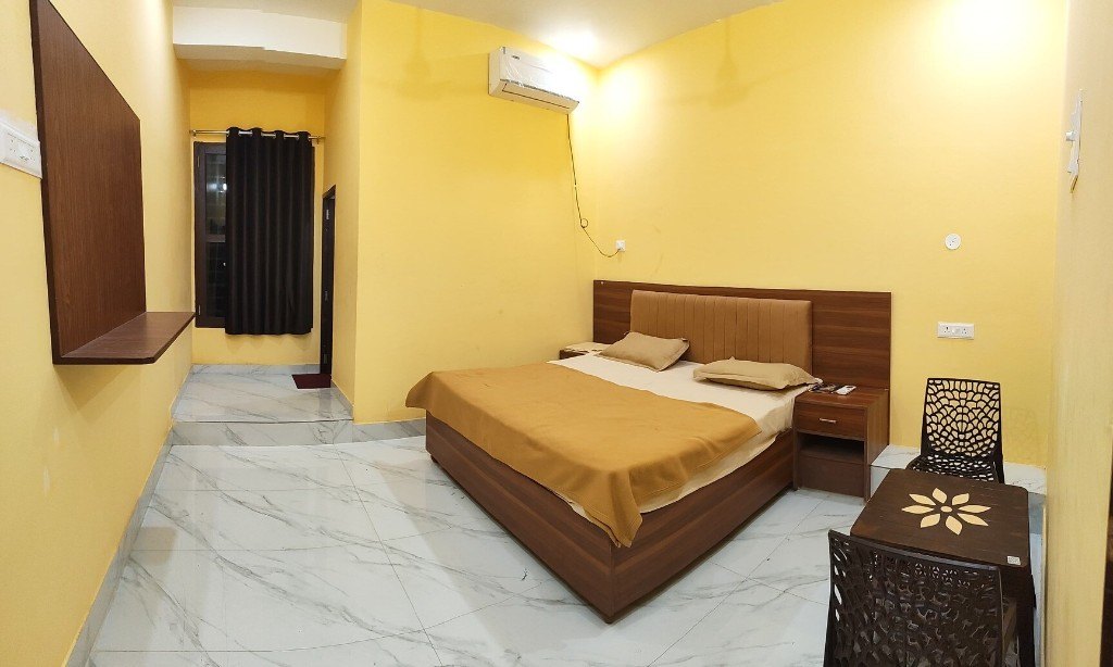 A room at Udaan Resort, with a bed, an air conditioner, and a small table