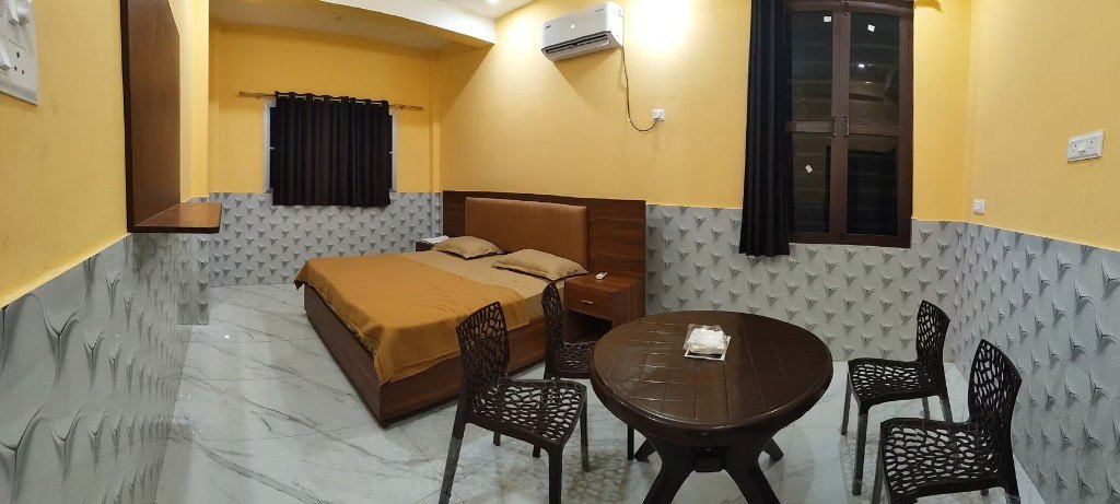 A room at Udaan Resort, with a bed, an air conditioner, and a round table